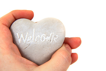 Image showing heart with word welcome ni human hands