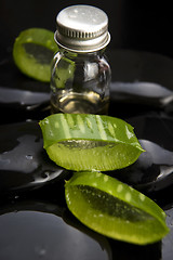 Image showing Sliced aloe leaves with oil on the stone