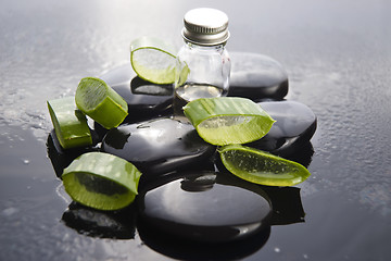 Image showing Sliced aloe leaves with oil on the stone