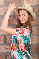 Image showing The beautiful girl in a summer hat. Studio portrait