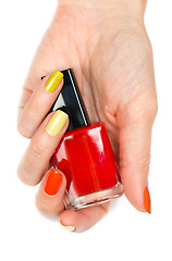 Image showing A bottle of red nail polish in a female hand
