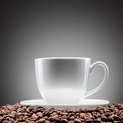 Image showing white cup with coffee beans on black