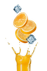 Image showing slices of orange falling into juice splash in glass isolated on 