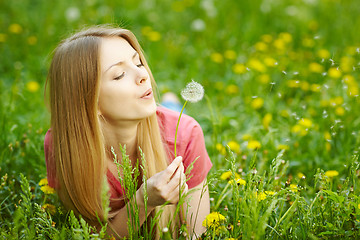 Image showing Girl blowing on a dandelion