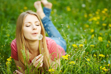 Image showing Girl blowing on a dandelion