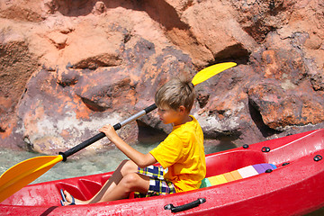 Image showing Happy boy paddling kayak on the river and enjoying a lovely summ