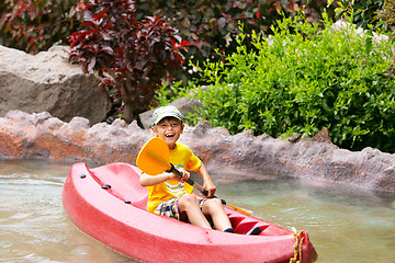 Image showing Happy boy paddling kayak on the river and enjoying a lovely summ