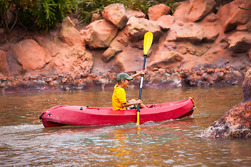 Image showing Happy boy paddling kayak on the river and enjoying a lovely summ