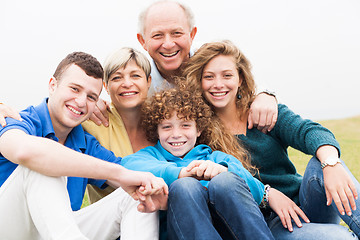 Image showing Portrait of family sitting on beach lawn