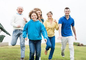 Image showing Smiling family running in the grass