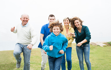 Image showing Happy family running on a green meadow