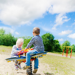 Image showing Boy and girl swinging on a swing