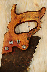 Image showing old rusty saw on wooden background with Grunge Filter