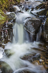 Image showing Small waterfall with icicles and ice close up, spring.