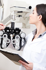 Image showing Optometrist Looking At Phoropter