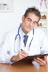 Image showing Male Doctor Writing on Clipboard