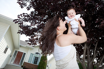 Image showing Mother Lifting Daughter Up And Smiling