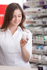 Image showing Female Pharmacist Reading Information On Medicine