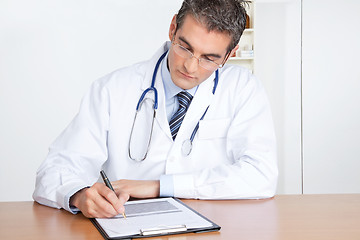 Image showing Male Doctor Writing on Clipboard