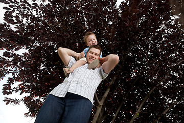 Image showing Portrait Of Boy Sitting On Father's Shoulders