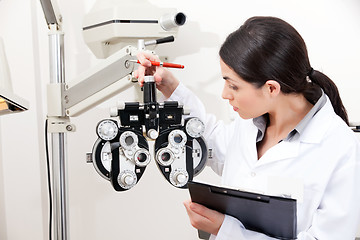 Image showing Optometrist Looking at Phoropter