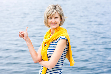 Image showing Middle age woman outdoors gesturing thumb up