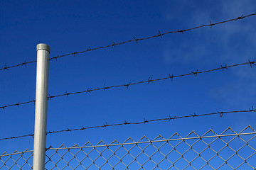 Image showing Barbed Wire Fence Against Blue Sky