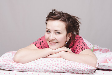 Image showing Young girl smiling lying in bed