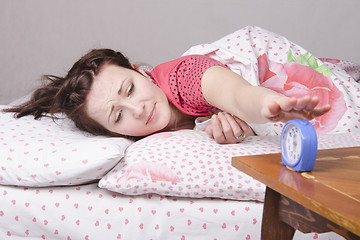 Image showing The girl ringing off clock in morning