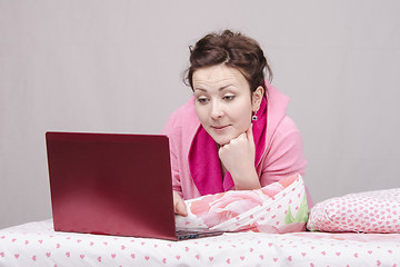 Image showing Girl in bed with interest works for laptop