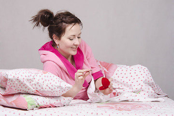 Image showing Girl in bed considers a gift ring