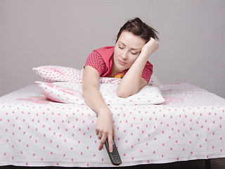 Image showing young girl fell asleep with remote control in bed