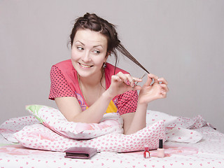 Image showing Girl cutting a lock of hair cuticle scissors