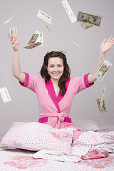 Image showing The girl on bed falling banknotes