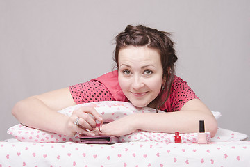 Image showing Girl in bed paints nails