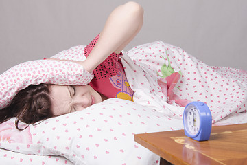 Image showing Girl wakes up the clock in morning