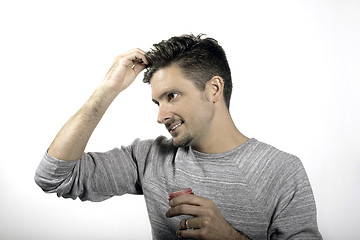 Image showing A male applying hair style product