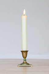 Image showing Burning candle on wooden table