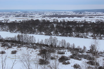 Image showing winter frozen river and forest on the background