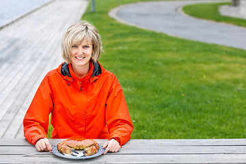 Image showing Happy woman eating crab outdoors