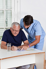 Image showing Mature Man playing Sudoku Puzzle