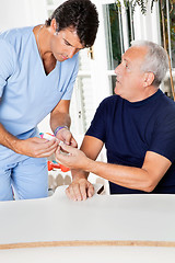 Image showing Male Nurse Checking Sugar Level Of Senior Man