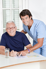 Image showing Mature Man playing Sudoku Puzzle