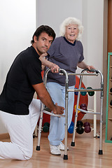 Image showing Therapist helping Patient use Walker