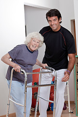 Image showing Therapist helping Patient use Walker