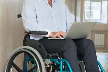 Image showing Man Sitting In Wheel Chair Using Laptop