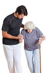 Image showing Trainer Assisting Senior Woman Holding Walking Stick