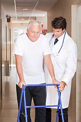 Image showing Doctor helping Patient use Walker
