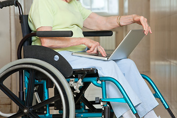 Image showing Senior Woman Sitting In Wheelchair Using Laptop