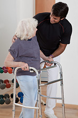 Image showing Therapist helping Patient use Walker